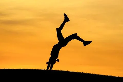 Girl does back bend at sunset. Stock Photos