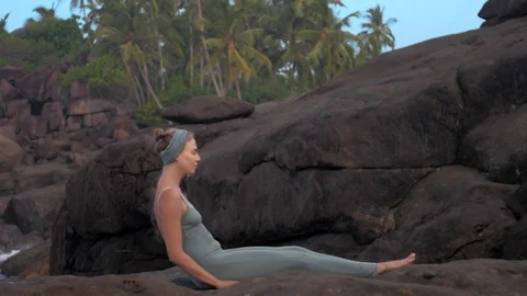 Girl does back somersault on large flat rocks slow motion Video stock 112266499