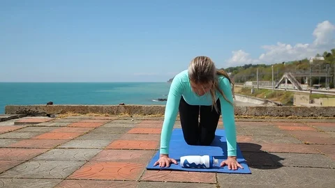The girl does exercises on the muscles of the buttocks by the sea Stock Footage 114554514