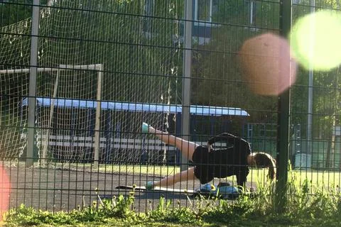 A girl does exercises at the stadium, Does the exercise movement of the legs  Stock Photos