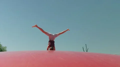 Girl does a Handstand on a Trampoline Slow Motion Stock Footage 344290677