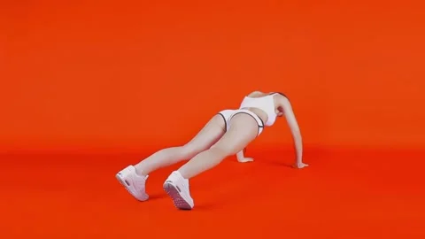 The girl does hard push-ups without a trainer. On a red background Video stock 241592290