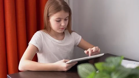 The girl does her homework and looks at the tablet. distance education. Stock Footage 176427632