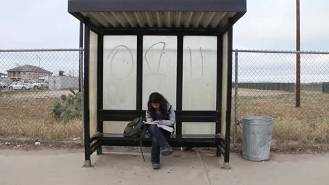 Girl does homework while waiting for bus Stock Footage 155488461
