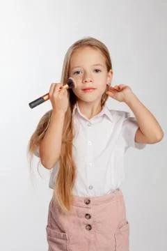 Girl does makeup using a powder brush Foto stock