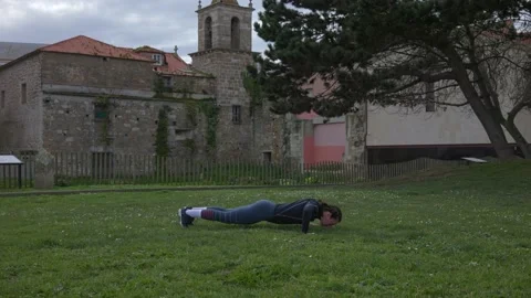 The girl does push-ups, playing sports on the street. Stock Footage 171483291