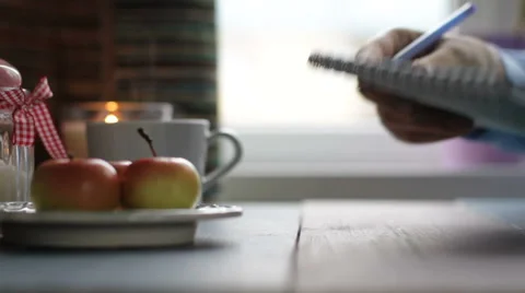 The girl does records in a notebook at the table 库存影片 68907592