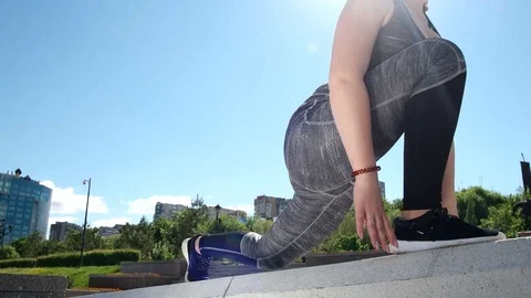 Girl does stretching and sits on twine in the street Stock Footage 76234037