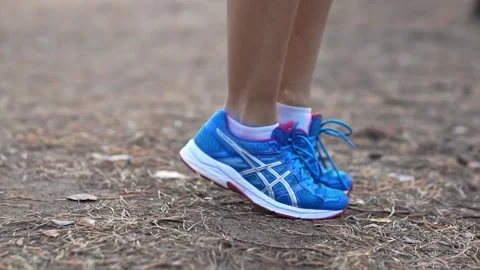 The girl does a warm-up in the park, close-up in sneakers. Healthy lifestyle Stock Footage 165202154