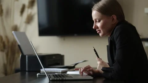 Girl does work from home on a remote computer at a desk with a notebook Stock Footage 139106624