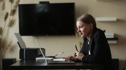 Girl does work from home on a remote computer at a desk with a notebook Stock Footage 139106659