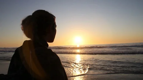 Girl doesn't move when the waves come right up to her Stock Footage 123200341
