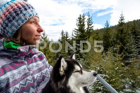 Girl with dog traveling on lift in the mountain. Stock Photos