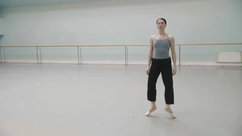 A girl doing ballet in an empty hall stretches her legs before a rehearsal Stock Footage 171231604