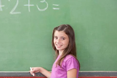 Girl doing an excercise of math and looking at camera 스톡 사진