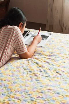Girl doing her homework using digital tablet. Stock Photos