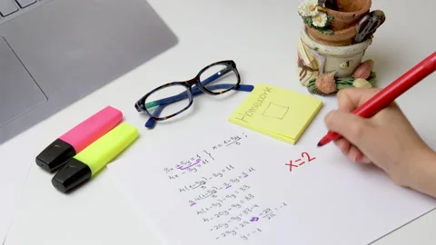 Girl doing homework at home solving a math problem with red marker Video stock 152995286