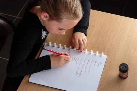 Girl doing homework in the kitchen Stock Photos