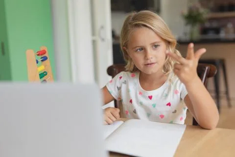 Girl doing homework at table in a comfortable home 스톡 사진