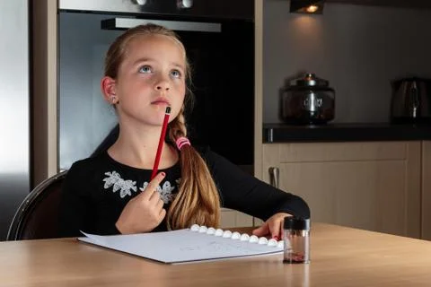 Girl doing homework thinking Stock Photos