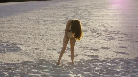 Girl doing impromptu dance moves on the sand at sunset Stock Footage 67487366