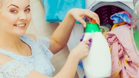 Girl doing laundry using liquid detergent Stock Photos