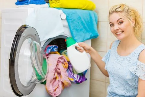 Girl doing laundry using liquid detergent Stock Photos