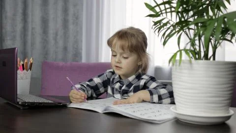 Girl doing lessons at home using digital laptop computer. Distance education Foto stock