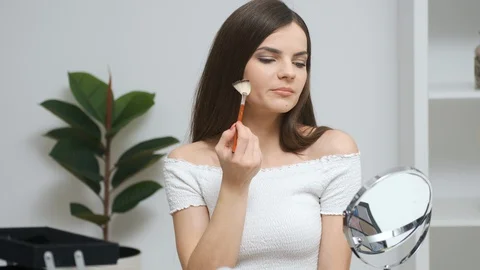 Girl doing makeup looking in the mirror Stock Footage 129047117