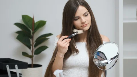 Girl doing makeup looking in the mirror Vídeo Stock 129049179