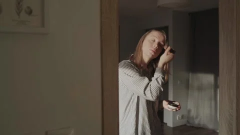 Girl doing makeup standing in front of the mirror Stock-Footage 143458187