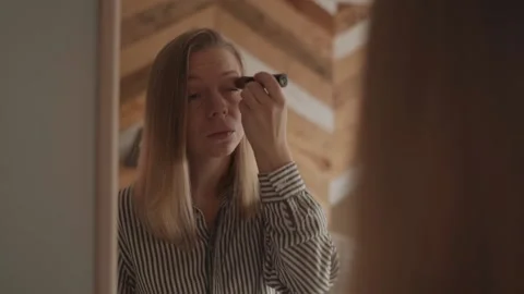 Girl doing makeup standing in front of the mirror Stock-Footage 143458305