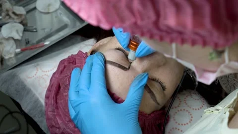 Girl doing permanent makeup eyebrows in the beauty salon. 스톡 동영상 99867268
