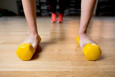 Girl doing push-ups using dumbbells. Stock Photos