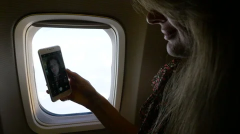 Girl doing selfie inside the plane near the window. HD Stock Footage 67186486