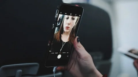 Girl doing selfie inside the plane. Young woman and her phone Stock Footage 88097419