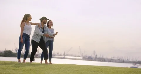 Girl doing some acrobatics while friends are cheering at her Stock Footage 84579395
