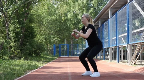Girl doing squat exercise outdoors. girl loses weight Stock Footage 69023842