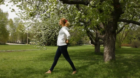 Girl doing stretching exercises in the spring garden Stock Footage 38422289