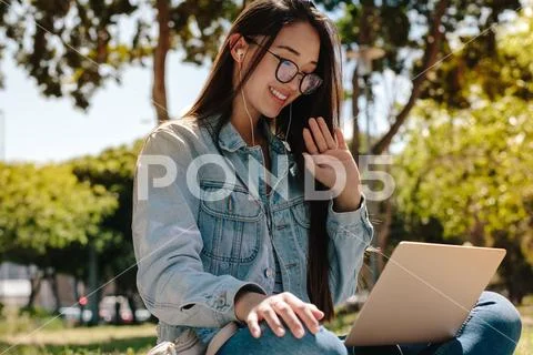 Girl doing a video chat sitting outdoors Stock Photos