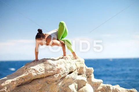 Girl doing yoga on the beach Stock Photos