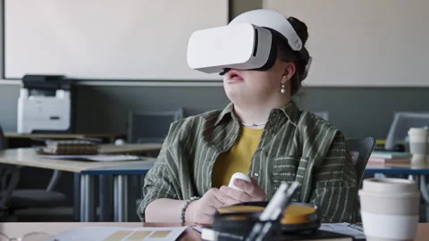Girl with Down Syndrome Using VR Headset with Remote Controller in Office Stock Footage 275075554