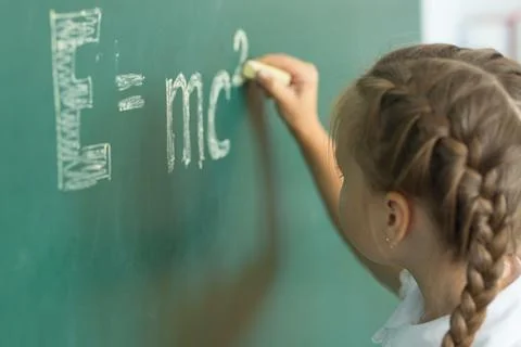 Girl drawing on chalkboard formula e mc2. Education and school concept Foto stock