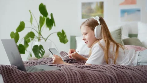 Girl drawing on tablet while looking at laptop Stock Footage 313052627