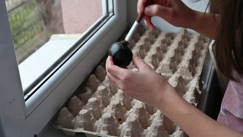 Girl draws an easter egg in black. Black Easter. Black easter egg Video stock 127813238