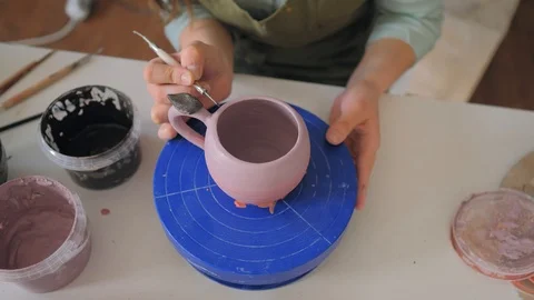 The girl draws a pattern on a clay cup closeup. Painting of clay products 動画素材 119546256