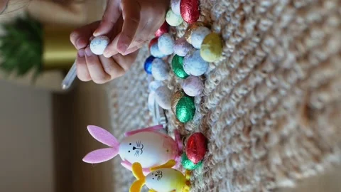 Girl draws a pattern on an Easter egg next to an egg in the shape of a rabbit Stock Footage 176288845