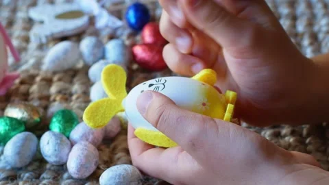 A girl draws a pattern on an Easter egg in the form of a rabbit with Easter eggs Stock Footage 176292895