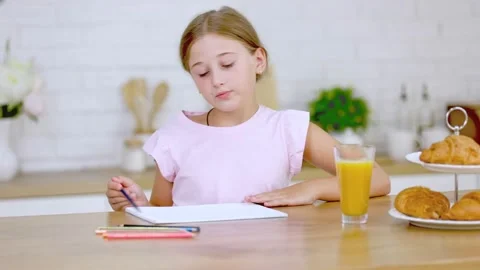 Girl draws while sitting in the kitchen Stock Footage 159398866