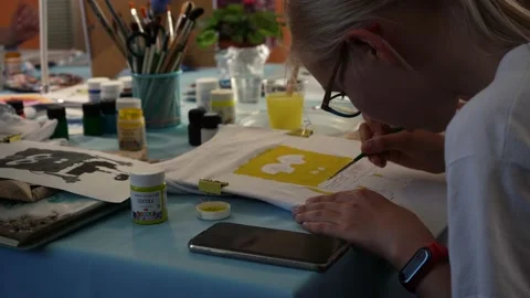Girl draws on a white sheet while sitting at the table. moscow russia 20 august Stock Footage 159828718